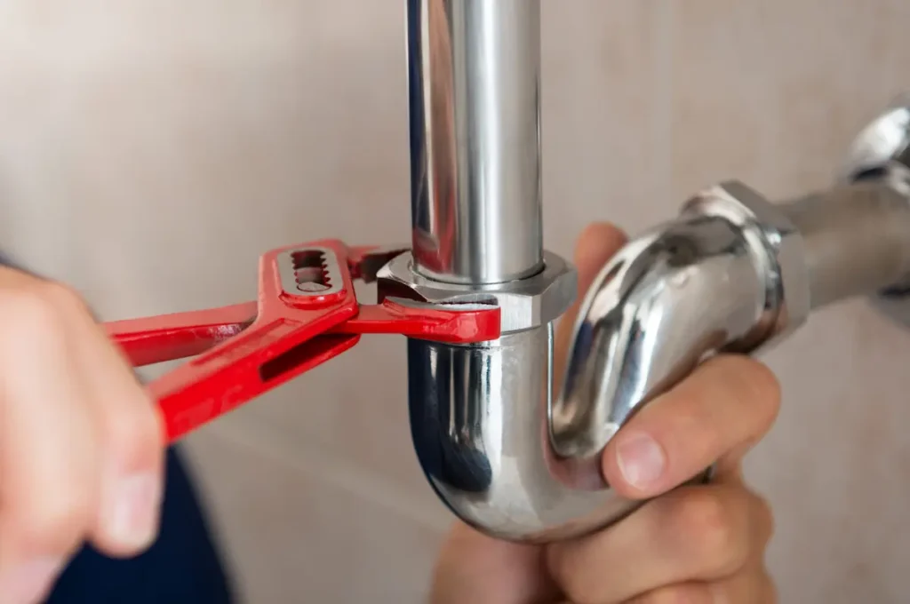Image of fixing a plumbing pipe, related to preventing moisture issues that attract pests