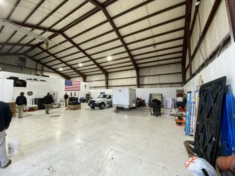 Pest control team working inside warehouse facility with equipment and vehicles