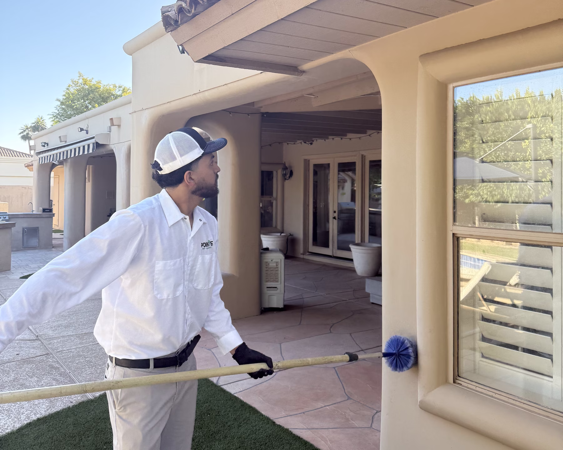 Pointe pest control technician working in the exterior of residential building